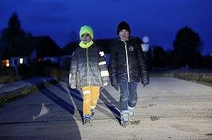 Sichtbarkeit im Straßenverkehr: Was für ein Unterschied: Das Kind links mit leuchtend gelber Mütze und Schal sowie reflektierenden Bändern ist gut sichtbar, das Kind rechts kann nur durch den Reißverschluss an der Jacke seine Sichtbarkeit etwas verbessern.
