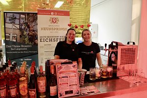 Karnevalsspektakel in einem gro&szlig;en Raum. Viele bunt gekleidete Menschen an Tischen und auf der B&uuml;hne
