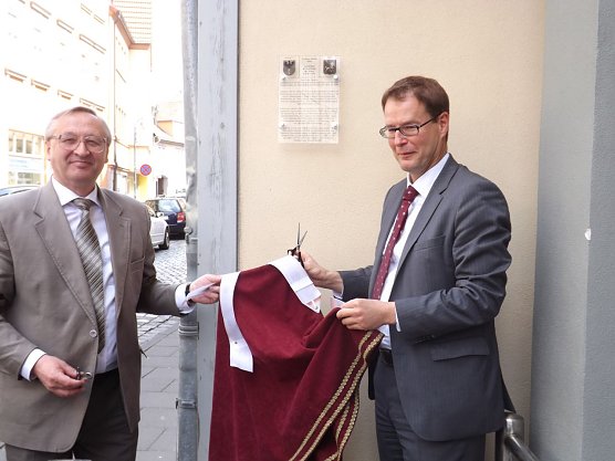 Evgeni Scholl und Oberb&uuml;rgermeister Dr. Johannes Bruns enth&uuml;llen die Gedenktafel in der R&ouml;blingstra&szlig;e. (Foto: Foto: Mix)