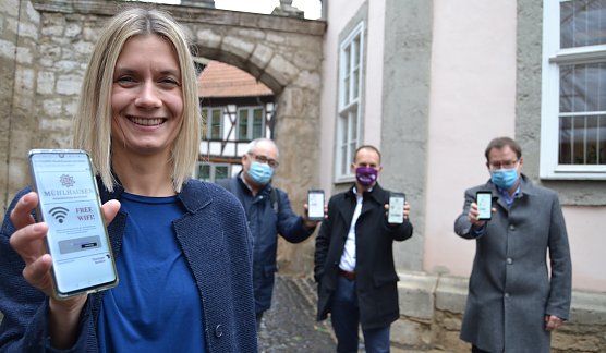 Ann-Kristin Zabel (Fachbereichsleiterin Wirtschaft und Soziales Stadt M&uuml;hlhausen), Oberb&uuml;rgermeister Johannes Bruns, Sven Wiedenh&ouml;ft (Th&uuml;ringer Netkom) und Frank Wender (Ingenieurb&uuml;ro Wender M&uuml;hlhausen) testen am Syndikatshof des Historischen Rathauses das Free Wifi M&uuml;hlhausen. (Foto: &copy; Stadtverwaltung M&uuml;hlhausen)