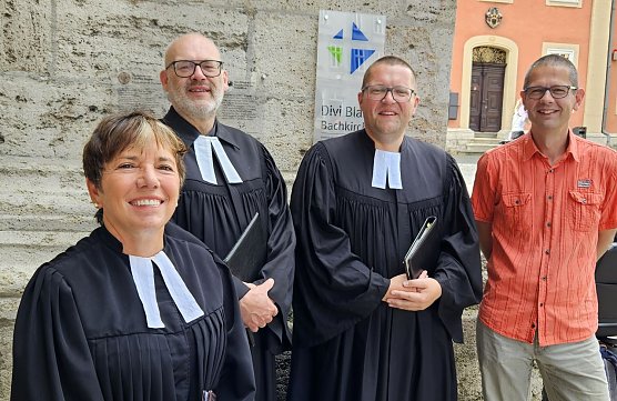 Dr. Margot K&auml;&szlig;mann, Pfarrer Marc Pokoj, Pfarrer Benjamin Themel und KMD Oliver Stechbart vor der Kirche Divi Blasii in M&uuml;hlhausen - im Rahmen der hochkar&auml;tig besetzten Predigtreihe "M&uuml;ntzer. Ein anderer Geist." (Foto: Kirchenkreis M&uuml;hlhausen, Regina Englert)