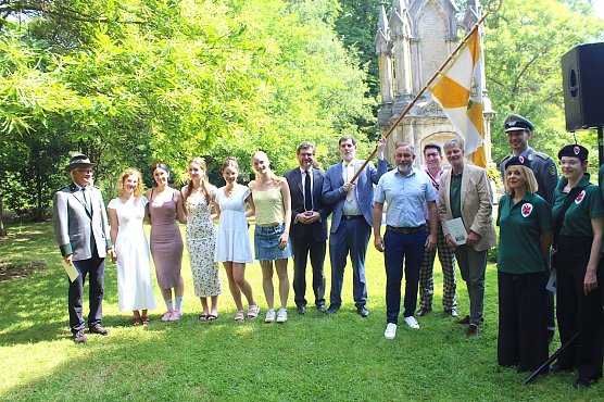 Bild: Sch&uuml;tzen, Sch&uuml;lerinnen, Hofstaat, B&uuml;rgermeister, Prinz, Offizier und italienische G&auml;ste vor dem Denkmal im Arboretum