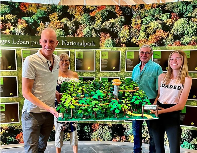 Bild: Sophie Gerstenberg mit ihren Gro&szlig;eltern Carmen und Dieter Baumgart aus Obergrunstedt &uuml;bergeben das 3D-Modell des Baumkronenpfades an Betriebsleiter Michael Zilling.