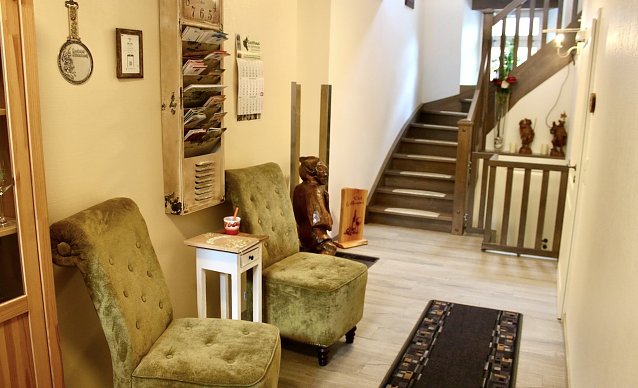 Bild: Treppenhaus im Pensionshaus Augustinerplatz 3: liebevolles Interieur, hier mit geschnitztem Hausgeist im Hintergrund