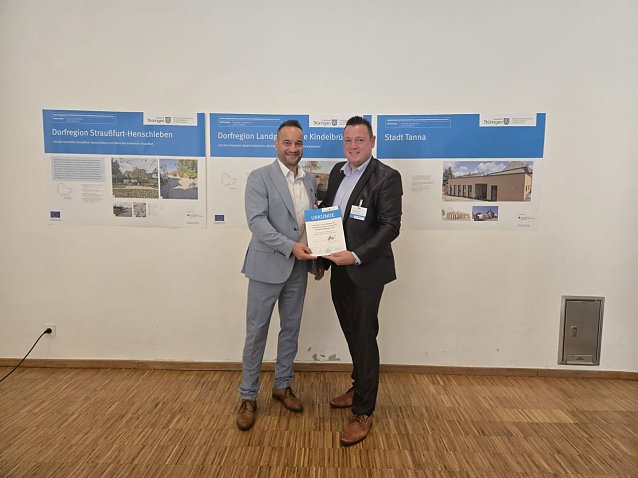 Bild: B&uuml;rgermeister Jan Riemann und Christoph Reimann, Fachbereichsleiter f&uuml;r Stadtentwicklung, nahmen die Urkunde f&uuml;r die Dorfregion M&uuml;hlhausen S&uuml;d am 21. August 2025 in Neustadt/Orla entgegen.