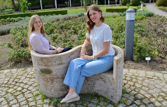 Bild: Zwei junge Frauen auf einer Bank im Rosengarten