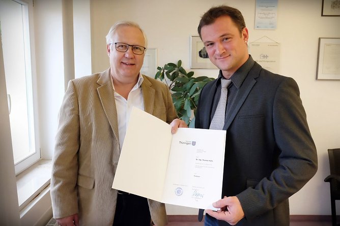 Der Vizepr&auml;sident f&uuml;r Studium und Lehre, Prof. Dr. Helmut Tilp, &uuml;bergibt die Ernennungsurkunde an Prof. Dr.-Ing. Thomas H&uuml;hn (rechts) (Foto: Tina Bergknapp/HSN)