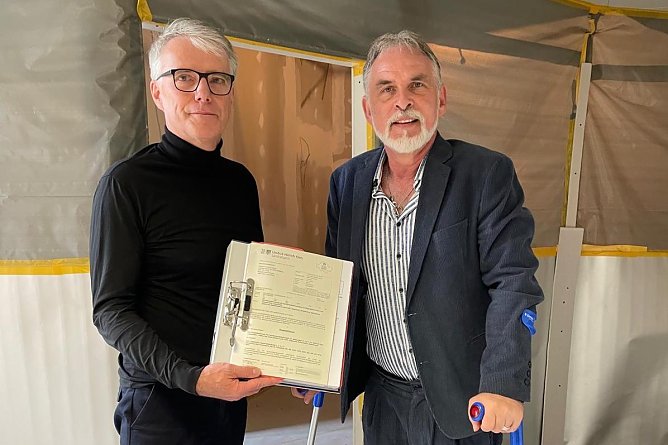 Der Gesch&auml;ftsf&uuml;hrer des Klinikums Jens Kopp und Landrat Harald Zanker (v. l.) mit der Baugenehmigung auf der Baustelle vor dem OP-Trakt am Standort Bad Langensalza (Foto: Landratsamt)