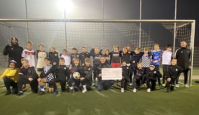 Toni Hyseni (vorne in der Mitte mit Scheck) &uuml;berreicht den Fu&szlig;ballern 1.000 Euro (Foto: FSV Preu&szlig;en)