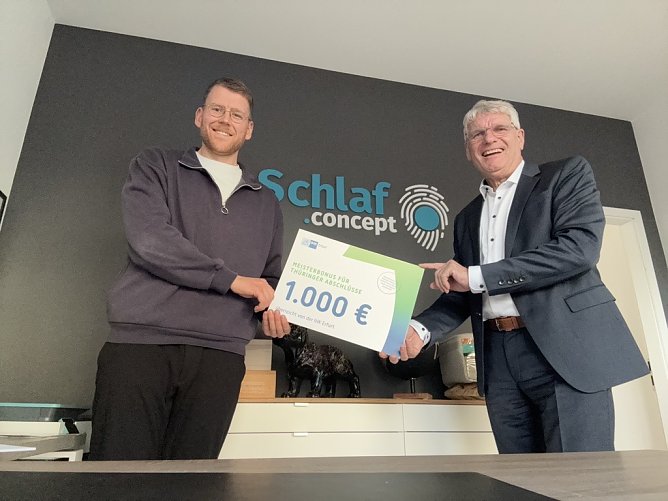 Florian Czischke ist einer der Absolventen der H&ouml;heren Berufsbildung, der sich im Dezember 2025 &uuml;ber die Auszahlung des Meisterbonus in H&ouml;he von 1.000 Euro freuen konnte. Den symbolischen Scheck &uuml;bergab Thomas Fahlbusch, Abteilungsleiter Aus- und Weiterbildung der IHK Erfurt. (Foto: IHK)