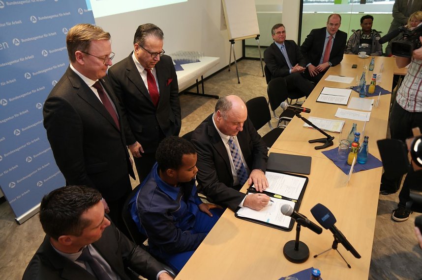 Helmut Peter unterzeichnet den Vertrag zur Einstiegsqualifizierung mit Michael Teclom Asmelash