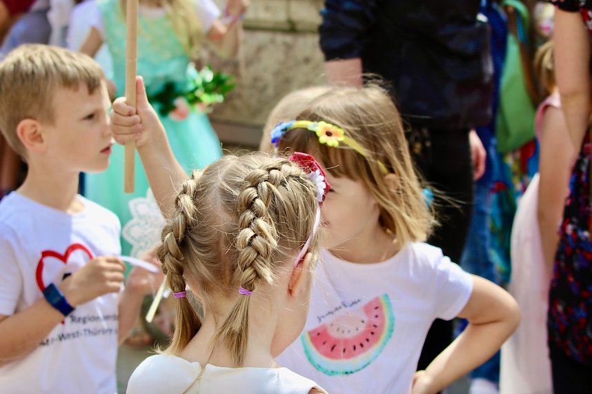 Auftakt zum Brunnenfest in Bad Langensalza mit vielen bunt geschm&uuml;ckten Kindern am Rathausbrunnen