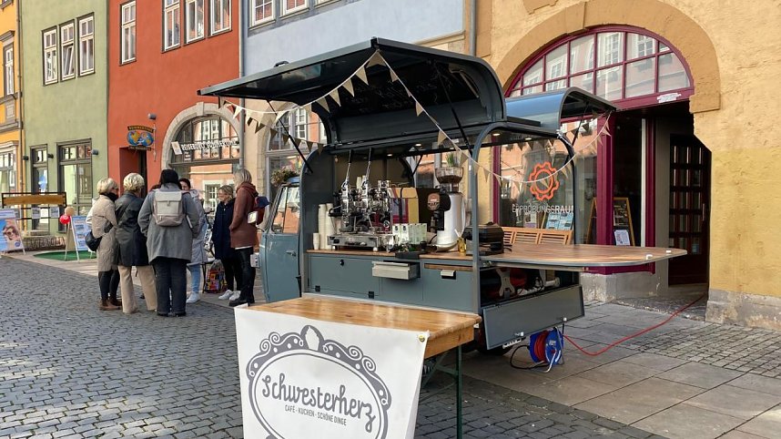 H&auml;ndler kommen aus ihren Gesch&auml;ften auf die Kunden zu